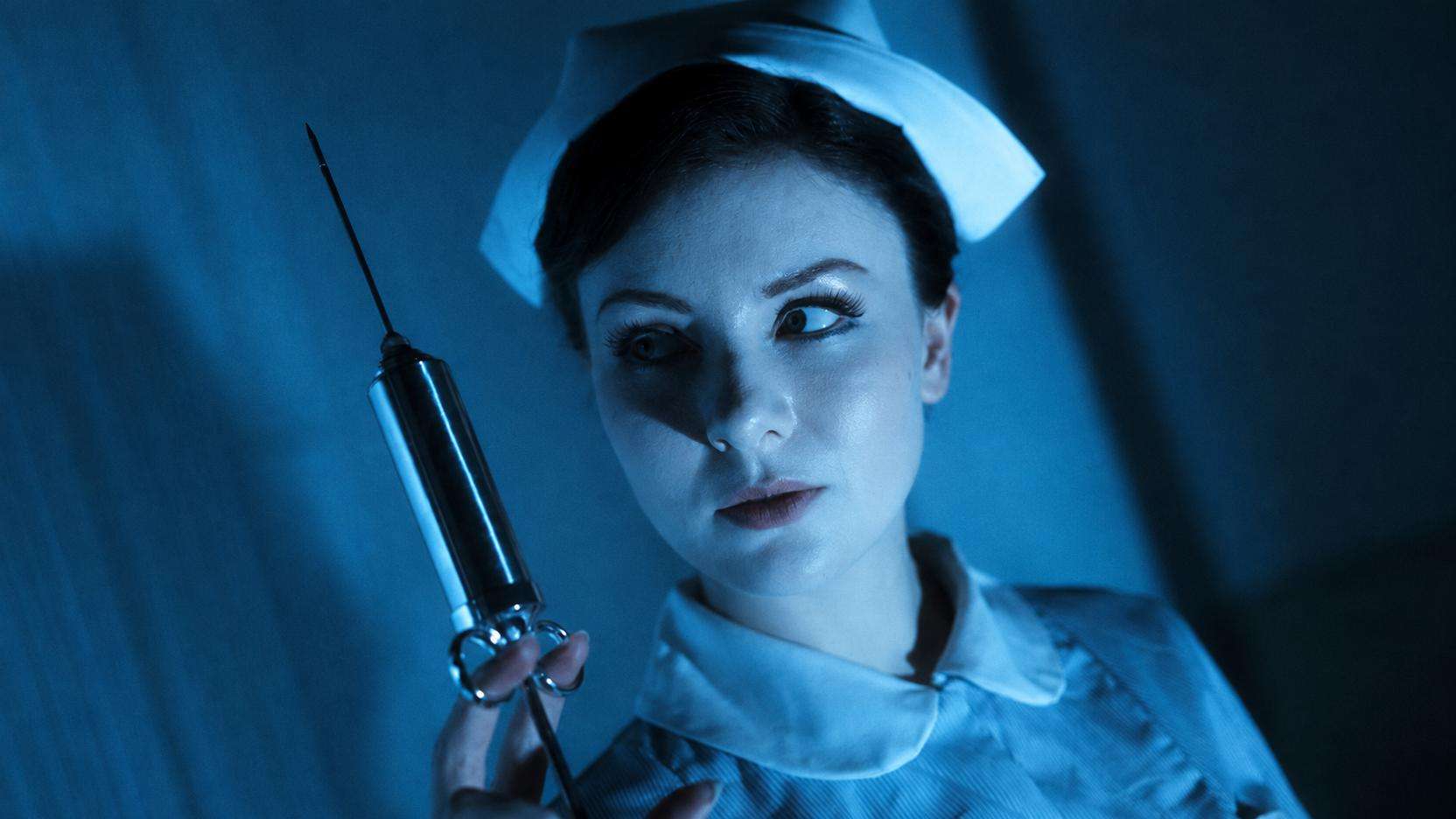 Megan Tremethick in nurse costume holding a syringe in In the Grip of Terror.